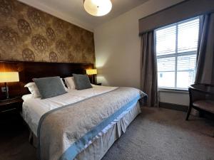 斯基普顿赫利厄特酒店的一间卧室设有一张大床和一个窗户。