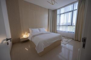 沙迦Villa Number 4的卧室设有白色的床和大窗户