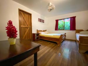 别霍港La Ruka Hostel的客房设有两张床、一张桌子和一扇窗户。
