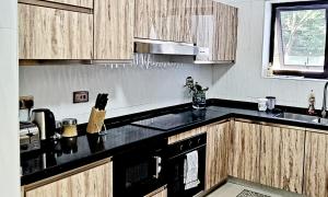 布兰太尔InstaHomes by Tru - Villa的厨房配有木制橱柜和黑色台面