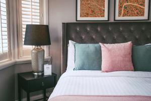克努斯福德玫瑰和皇冠酒店的一间卧室配有一张床和一张桌子上的台灯