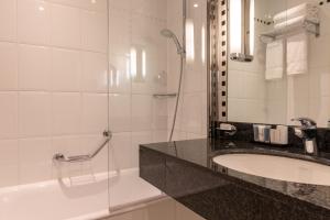 巴黎Crowne Plaza Paris République, an IHG Hotel的浴室配有水槽、淋浴和浴缸。