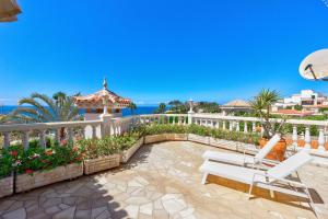 阿德耶Luxury villa El Duque Ocean View的庭院设有白色的围栏和长凳