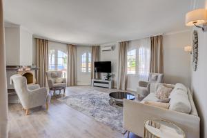阿德耶Luxury villa El Duque Ocean View的客厅配有沙发、椅子和电视