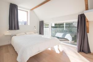 Lo-ReningeHet Wagenhuis的白色的卧室设有一张大床和一个窗户