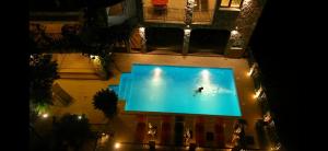 布德瓦Apartments Villa Čučuk的夜间在游泳池游泳的人的头顶景色
