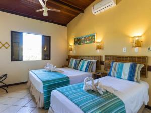 伊塔齐米林Pousada Praia das Ondas - Pé na areia的酒店客房,配有两张带毛巾的床