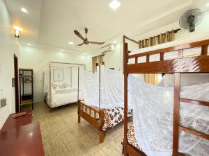 峰牙Phong Nha Farmstay的一间卧室设有两张双层床和吊扇