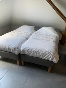 伦德't Brouwershuis的客房内的两张单人床,配有白色床单