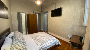 波哥大REPUBLICANA CASA HOSTAL - HABITACION 5 TAIRONA的卧室配有一张床,墙上配有电视。