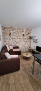 ChâteaubourgAppartement chaleureux en Ardèche的客厅设有两张沙发和砖墙