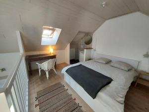 JanzéAppartement Duplex très lumineux en centre ville的阁楼上一间卧室配有床和书桌