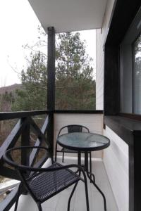 科索夫Villa Medova的阳台配有桌椅和窗户