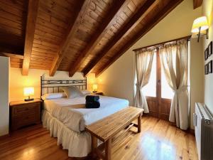 埃斯波特El Dúplex de Espot的一间卧室设有一张大床和木制天花板