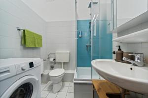 威廉港Infinity Stay: Bis zu 4 Personen Zentrum Wassernah Netflix的一间带洗衣机和水槽的浴室