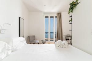 锡拉库扎La Vacanza Ortigia的白色卧室设有一张大床和一个阳台