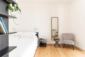 锡拉库扎La Vacanza Ortigia的一间卧室配有一张床、镜子和椅子