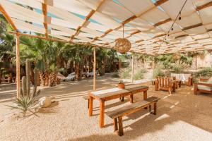 托多斯桑托斯Cien Palmas- Authentic Mexican Casita 1 -Downtown的天井设有木桌和帐篷下的长凳