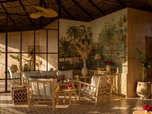 马拉喀什CASA ABRACADABRA的用餐室配有桌椅和壁画