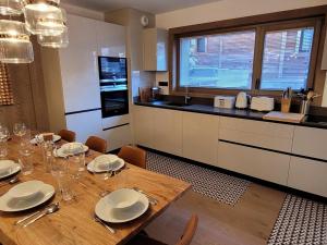 莱热Appartement Les Gets, 5 pièces, 8 personnes - FR-1-598-99的厨房配有带板和银器的木桌