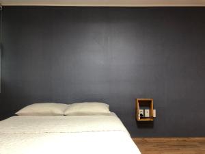 木浦市Jo Eun Jip Guesthouse的卧室配有白色的床和黑色墙壁