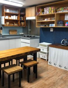 木浦市Jo Eun Jip Guesthouse的厨房配有木桌和长凳