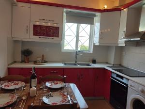 MelissátikaOrion - Charming 1-bedroom condo at convenient location.的厨房配有红色橱柜和一张桌子,上面有盘子