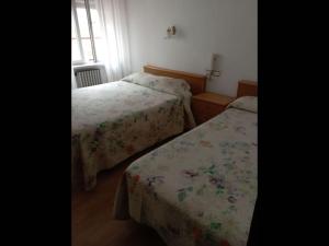 卢阿尔卡Room in Lodge - Pension Oria Luarca Asturias的一间卧室设有两张床和窗户。