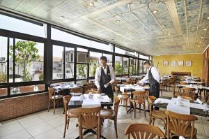 圣地亚哥格兰派乐斯酒店的两人站在带桌椅的餐厅