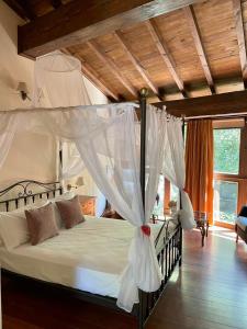 SarreausAldea Couso Rural的卧室配有带白色窗帘的天蓬床