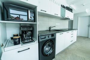奥拉迪亚Catharsis House - self check in and self checkout的厨房配有洗衣机和微波炉。