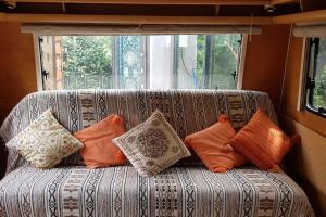 米米藏L'hermitage d'Apollon au sein d'un jardin forêt près de l'océan的窗户前的沙发上配有枕头