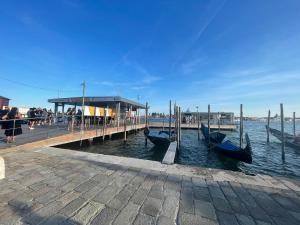 威尼斯Ca' ai Sospiri的水中设有几个贡多拉船的码头