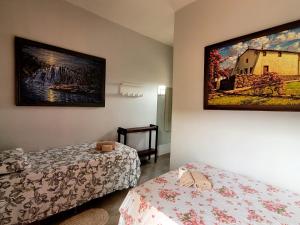 戈亚斯州上帕莱索Atelier & Pousada Chapada的一间设有两张床的客房,墙上挂着一幅画