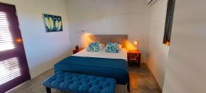 克拉伦代克Villa Carina Apartments的一间小卧室,配有床和蓝色凳子