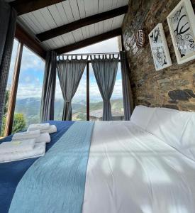 A PontenovaComplejo Rural Lar de Vies的一间卧室设有一张床和大窗户