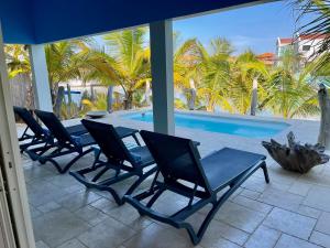 克拉伦代克Caribbean Lofts Bonaire的游泳池旁的一排椅子