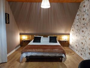 卢代阿克L'escale d'Armor的一间卧室配有一张带2个床头柜的大床