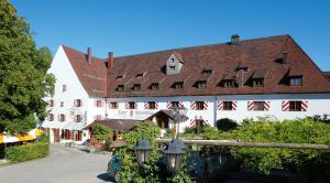 Irsee伊尔塞尔修道院啤酒厂酒店的一座白色的大建筑,有红色的屋顶