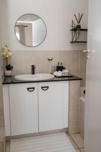 约翰内斯堡Nal'enzo Luxe Stays的浴室设有白色水槽和镜子