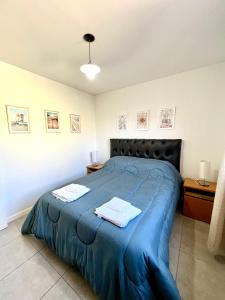 门多萨Lumiere Apartments - Departamento en Complejo Residencial的一间卧室配有蓝色的床和2条毛巾