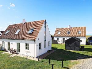 诺尔林格比Holiday Home Lyngbyvej V的两座白色房子,在草地上设有红色屋顶