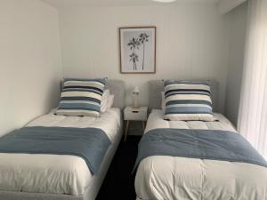 黄金海岸La Pacifique Apartments的卧室内两张并排的床