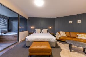 蒙特维尔Luxury Spa Retreat with Ocean and Hinterland Views的一间卧室配有一张床和一张沙发