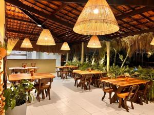 圣米格尔-杜斯米拉格里斯Kaçuá Milagres的餐厅设有木桌和椅子及灯