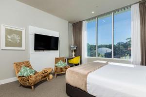 凯恩斯凯恩斯太平洋大酒店的酒店客房设有一张床和一个大窗户