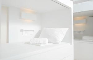 长滩岛The A Hostel的白色客房 - 带白色枕头的床