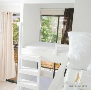 长滩岛The A Hostel的窗户客房内的一张白色双层床