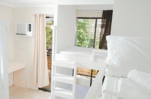 长滩岛The A Hostel的卧室配有白色双层床和窗户。