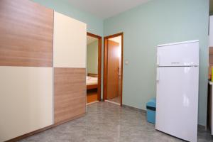 泰斯Apartments by the sea Nemira, Omis - 17039的带冰箱的客房和一间卧室